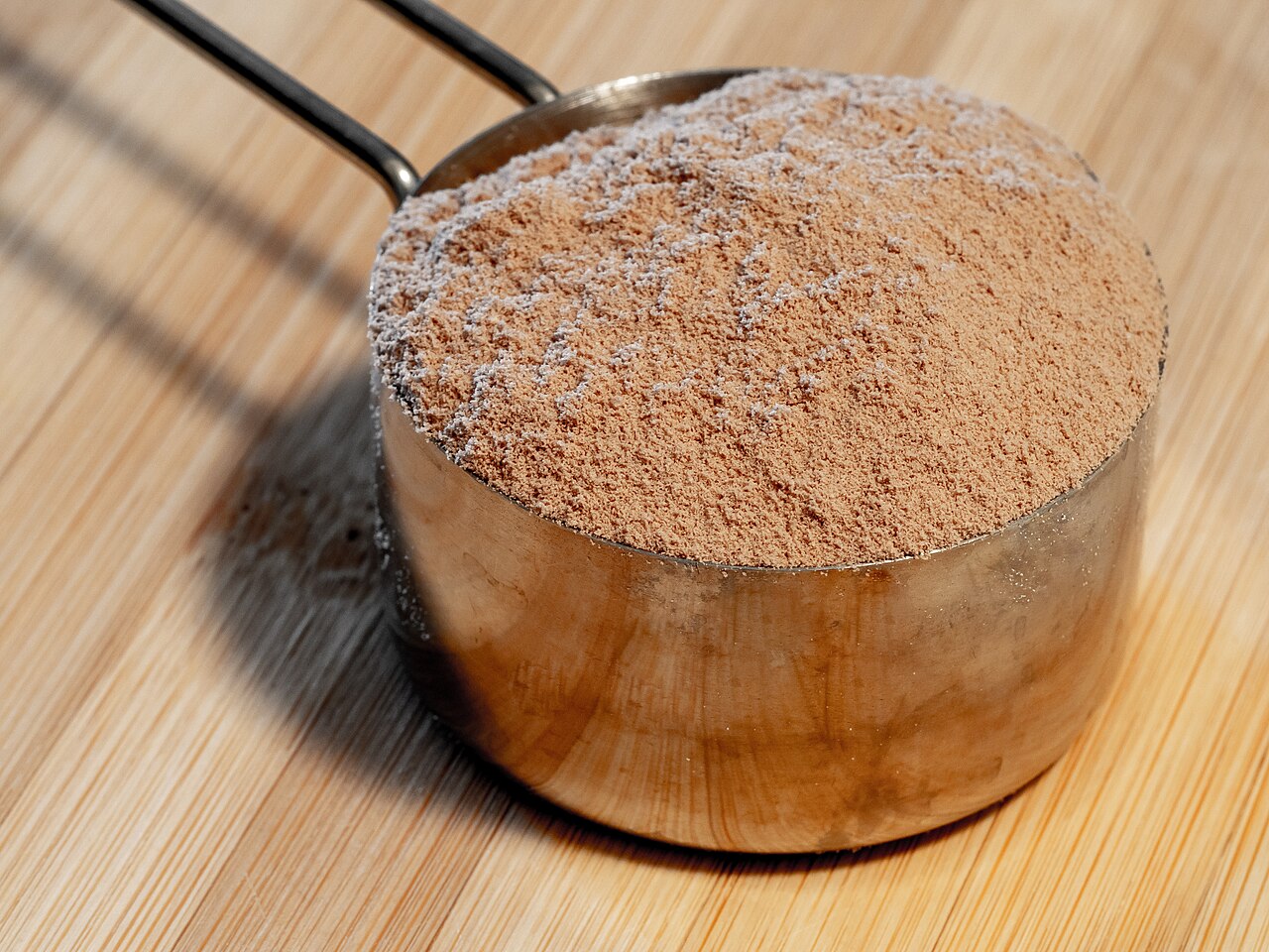 A scoop of whey protein powder representing protein supplements used with resistance training.